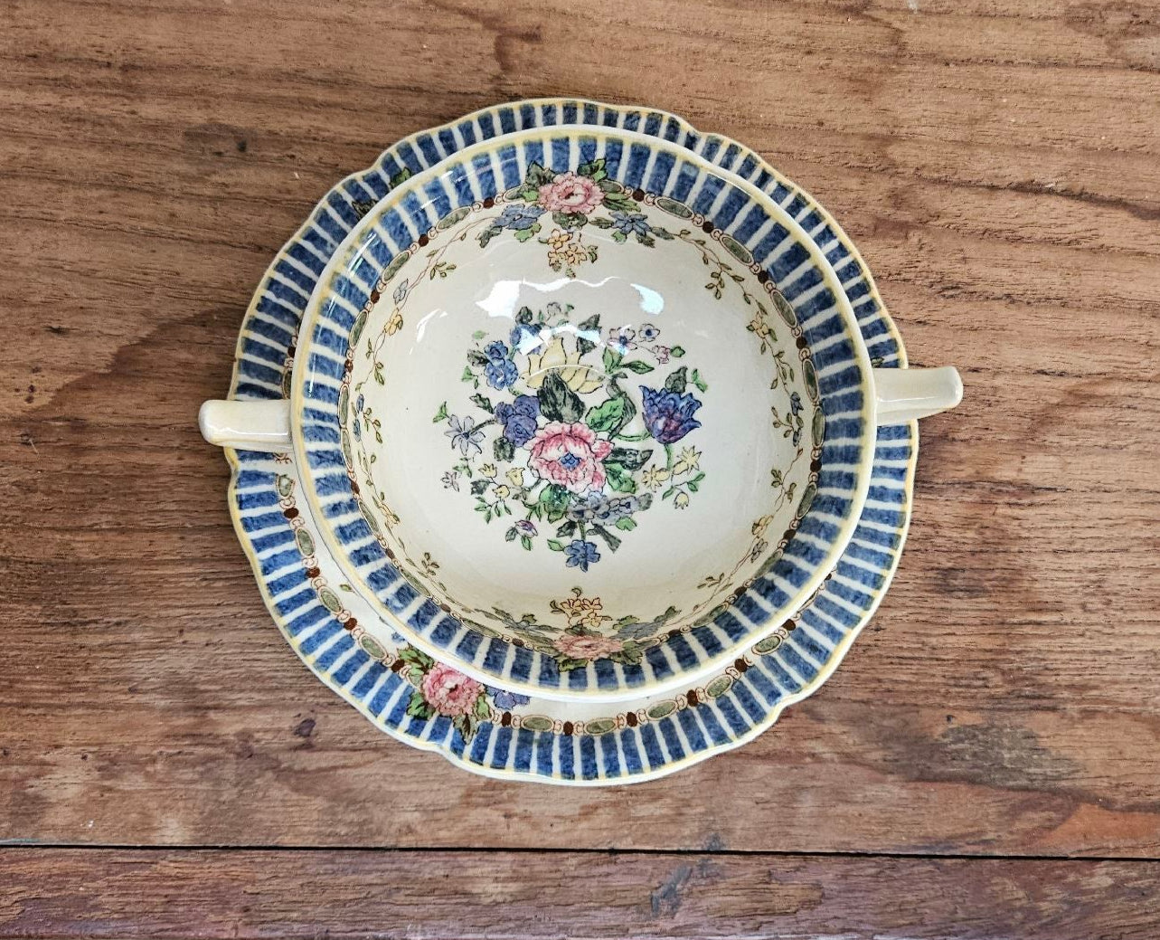 Floral, handpainted ceramic cup and saucer viewed from above.