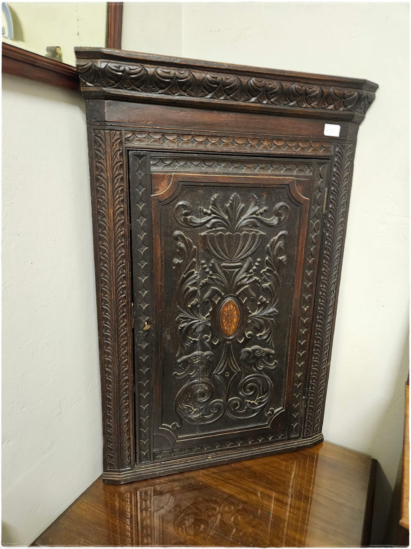Ornately carved corner cabinet